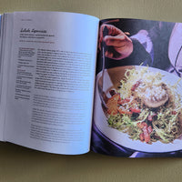 Open book showing a recipe with a photograph of a dish on a green background