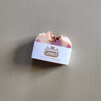 Bar of soap with a 'Larrea' label on a gray background