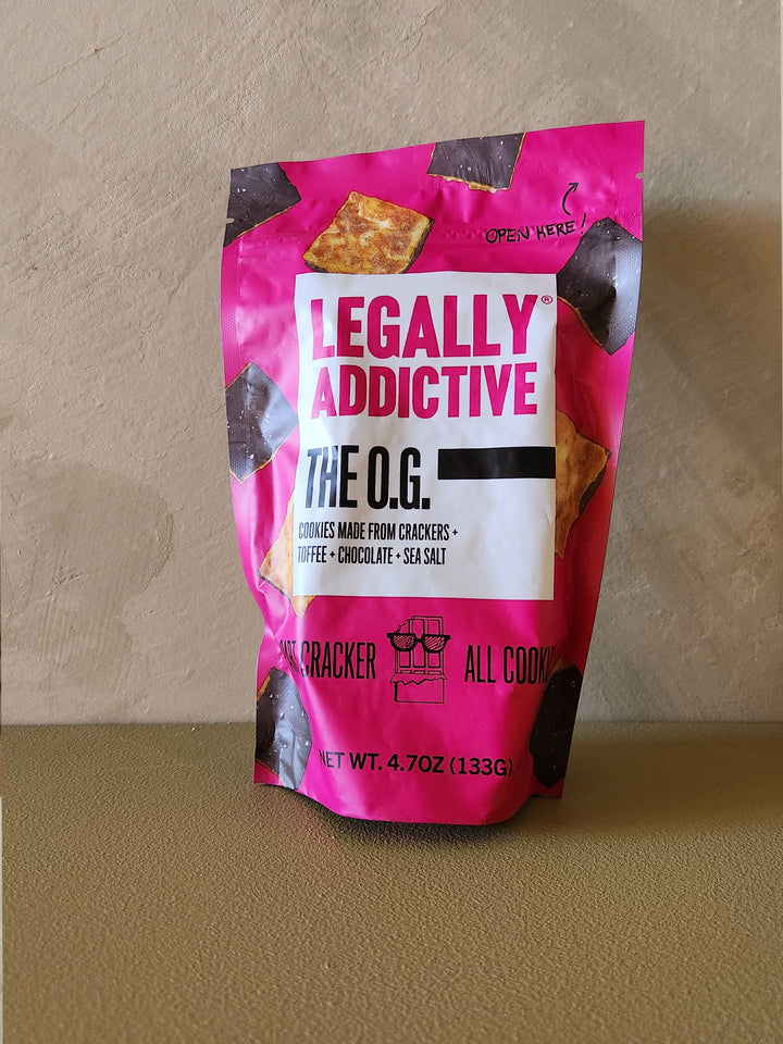 Pink snack bag labeled 'Legally Addictive' on a beige background