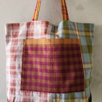 Plaid tote bag with colorful pattern on a plain background