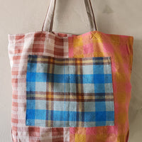 Colorful plaid tote bag with a plain background