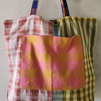 Colorful patchwork tote bag with plaid patterns on a plain background