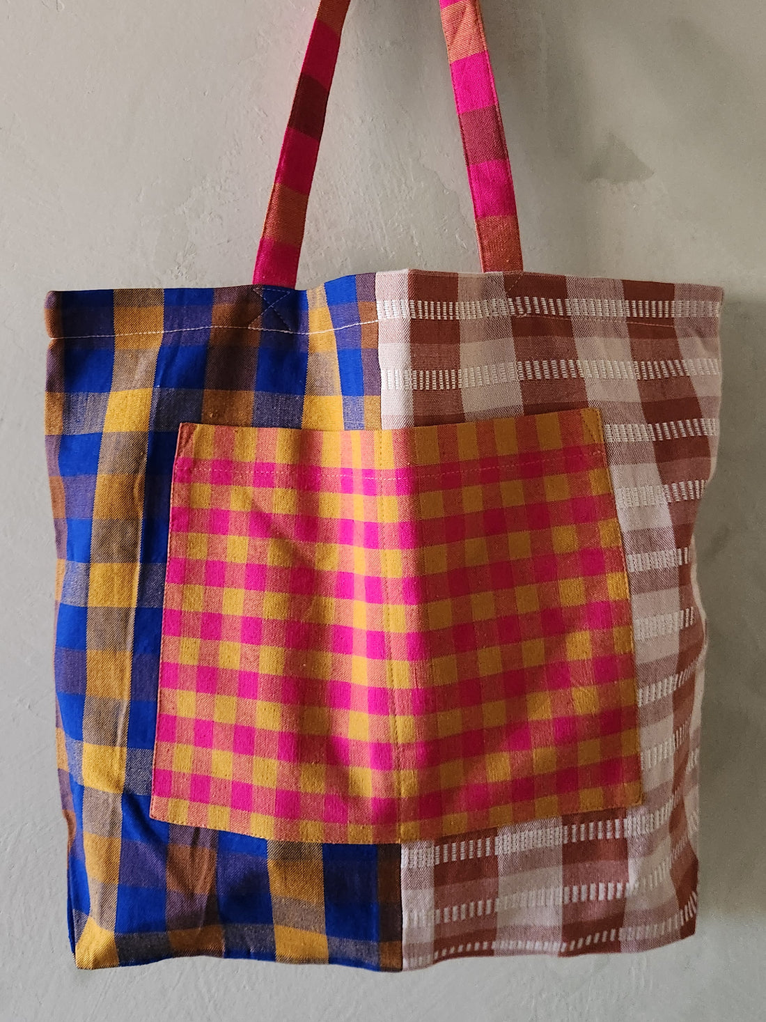 Colorful plaid tote bag on a plain background