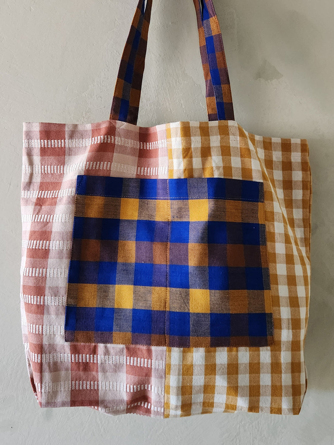 Plaid tote bag with a mix of colors on a plain background
