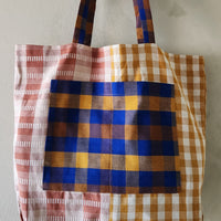 Plaid tote bag with a mix of colors on a plain background