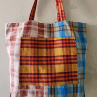 Plaid tote bag with red, blue, and yellow pattern on a plain background
