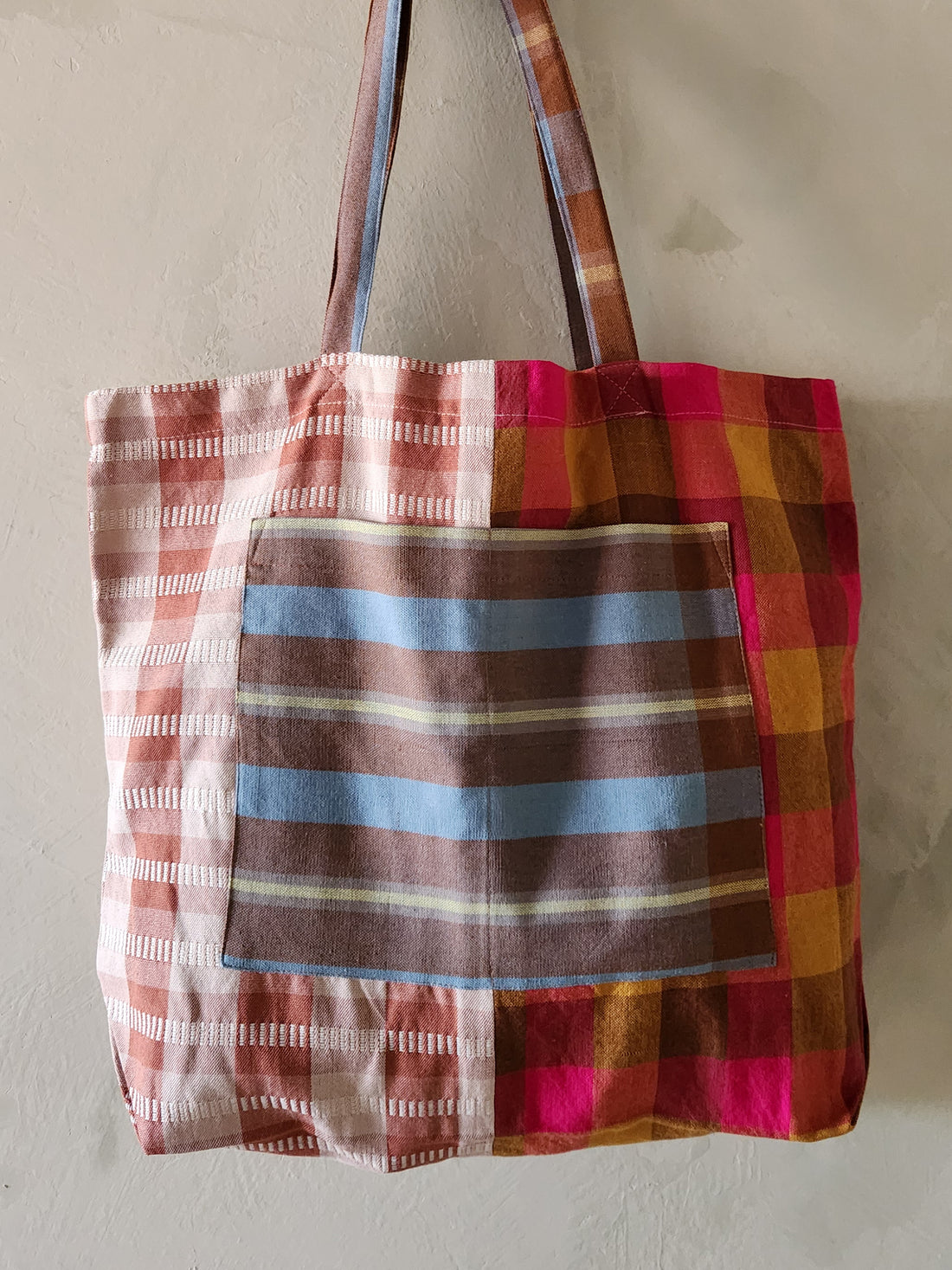 Plaid tote bag with multicolor pattern on a plain background