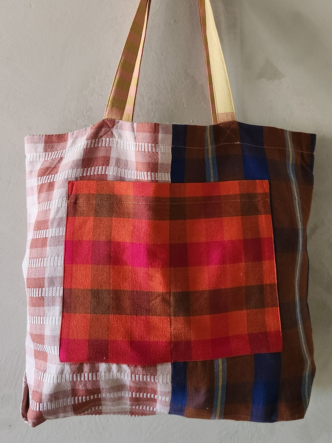 Plaid patterned tote bag with a mix of colors on a plain background