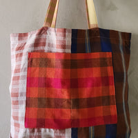 Plaid patterned tote bag with a mix of colors on a plain background