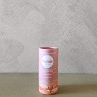 Pink cylindrical product packaging with 'humble' branding on a gray background