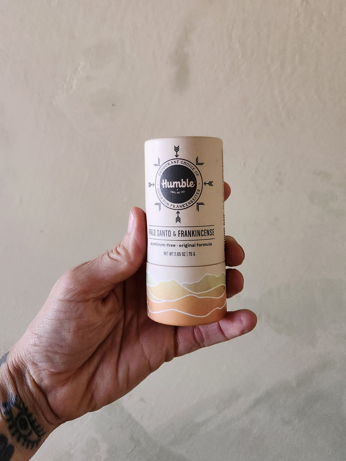 Hand holding a cylindrical product with &