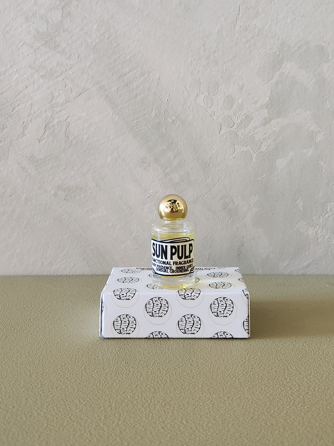 A small glass bottle with a gold cap and a black-and-white label reading &