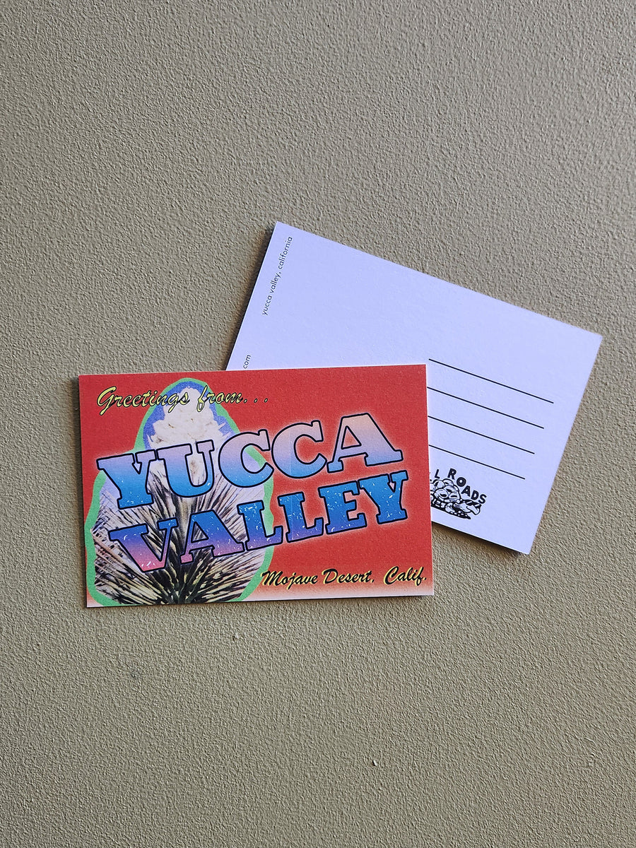 Colorful postcard with 'Yucca Valley' text on a gray surface
