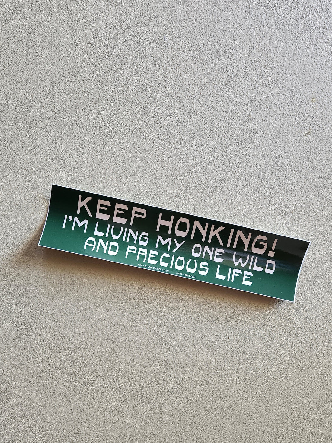 A bumper sticker that reads "Keep honking! I&