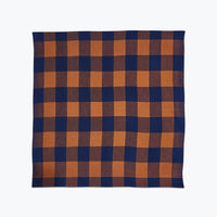 Plaid napkin in saddle brown and navy blue. 