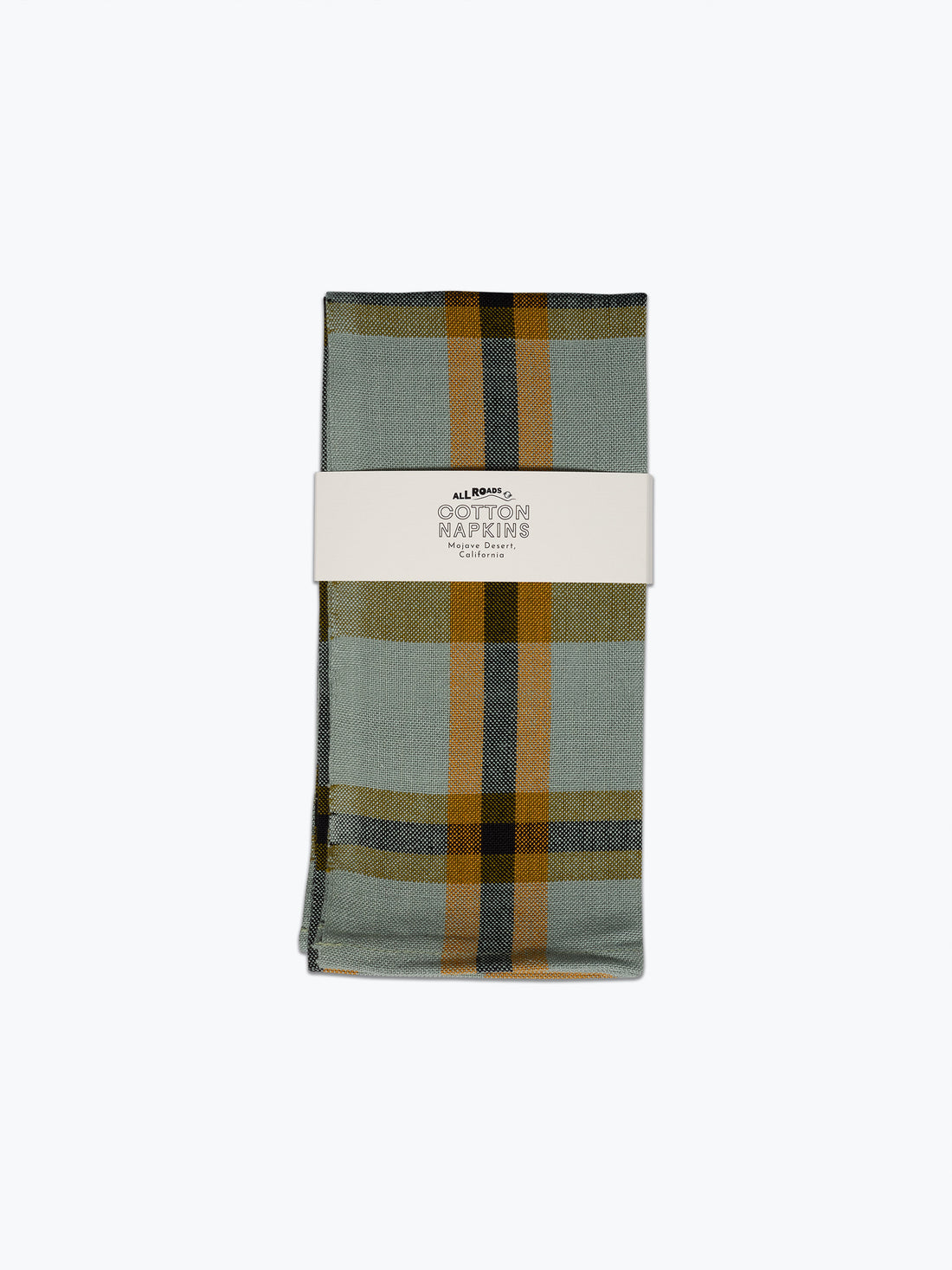 A folded cotton napkin with a muted sage green and mustard yellow plaid pattern, wrapped in a white paper band labeled &