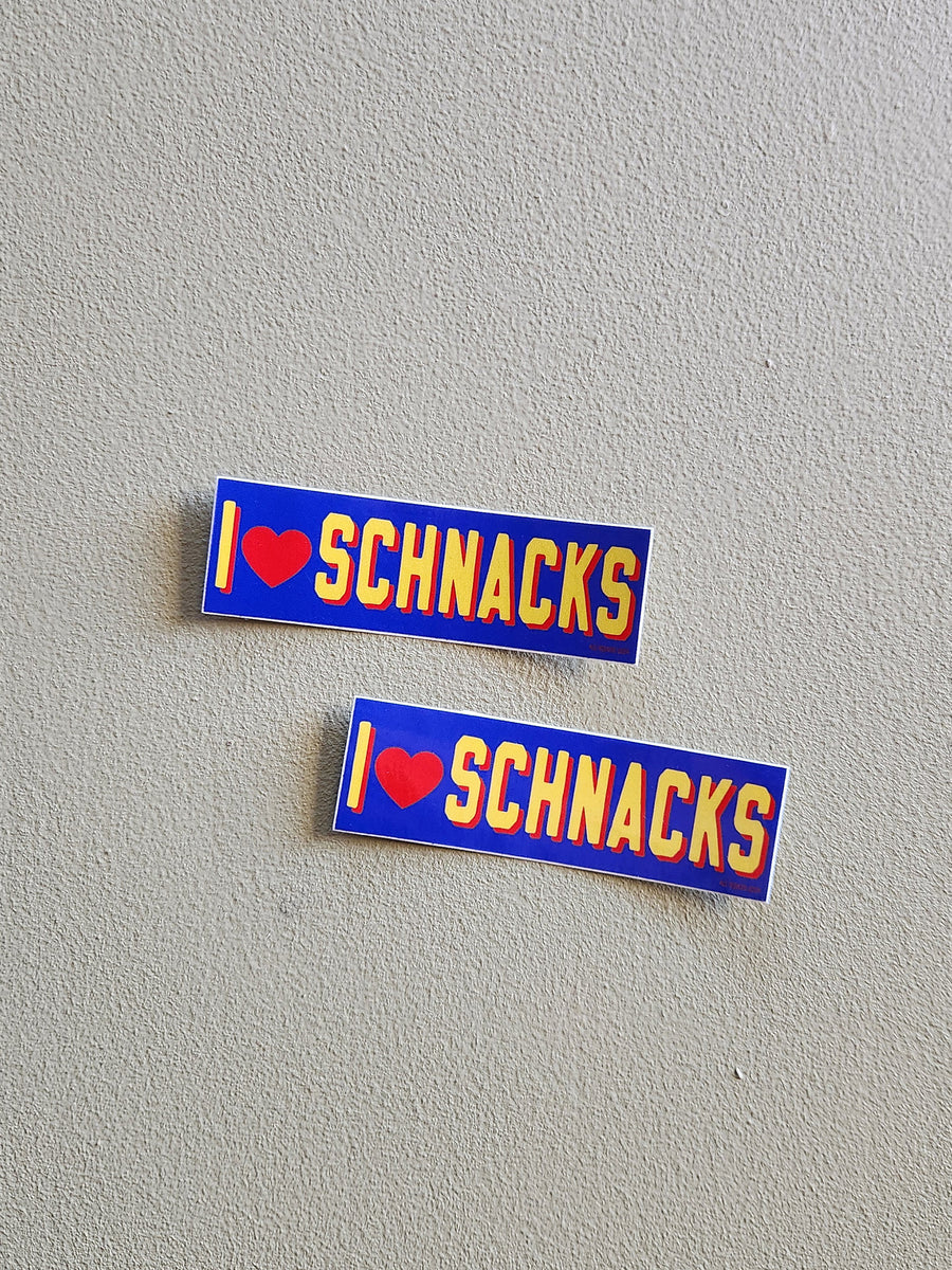 Two 'I ❤️ SCHNACKS' stickers on a gray background