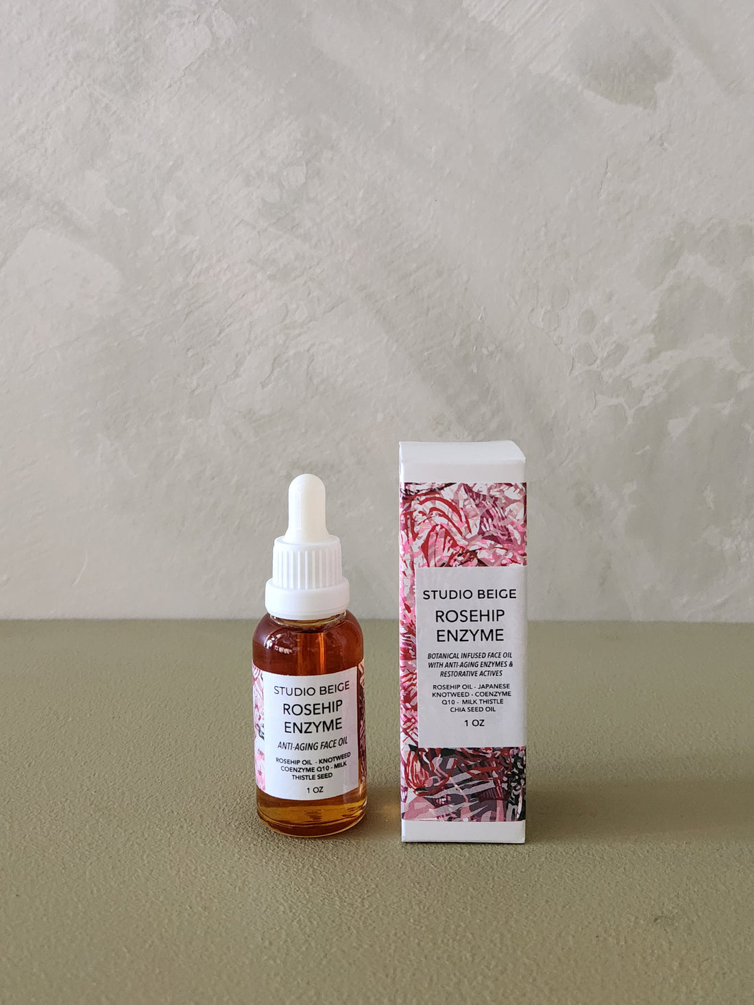 Bottle and packaging of Studio Beige Rosehip Enzyme on a neutral background