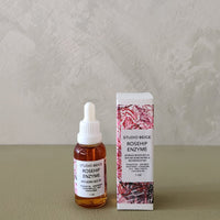 Bottle and packaging of Studio Beige Rosehip Enzyme on a neutral background