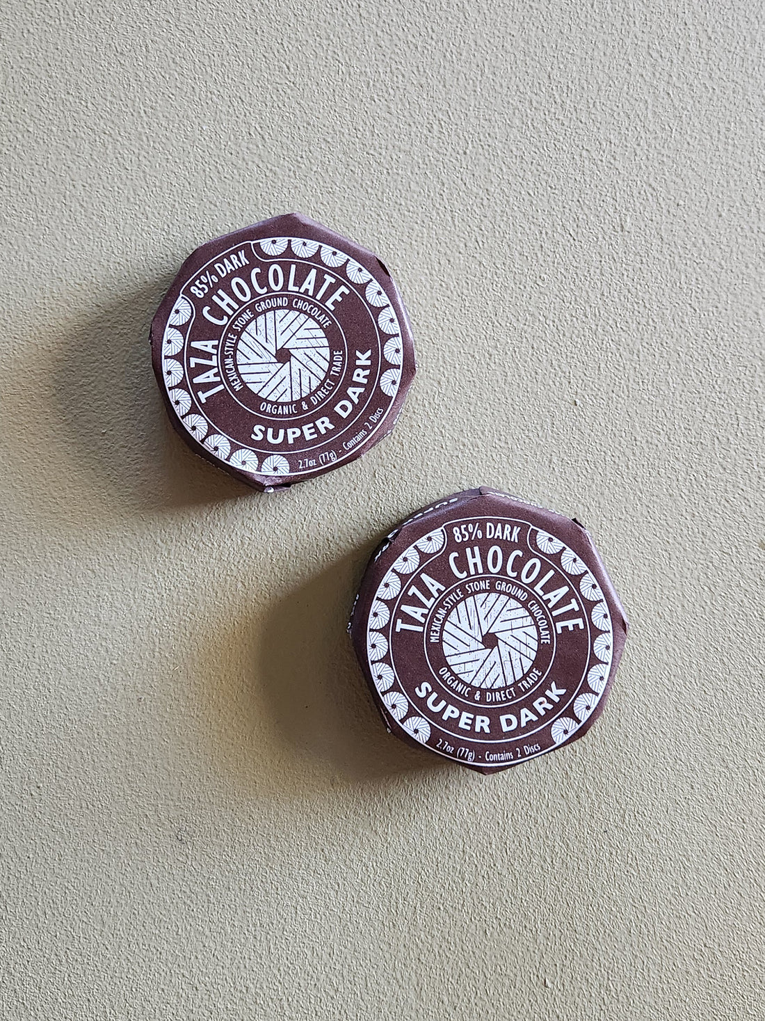 Two Taza Chocolate super dark chocolate bars on a light gray background