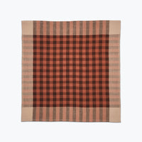 Plaid blanket with red and brown pattern on a white background