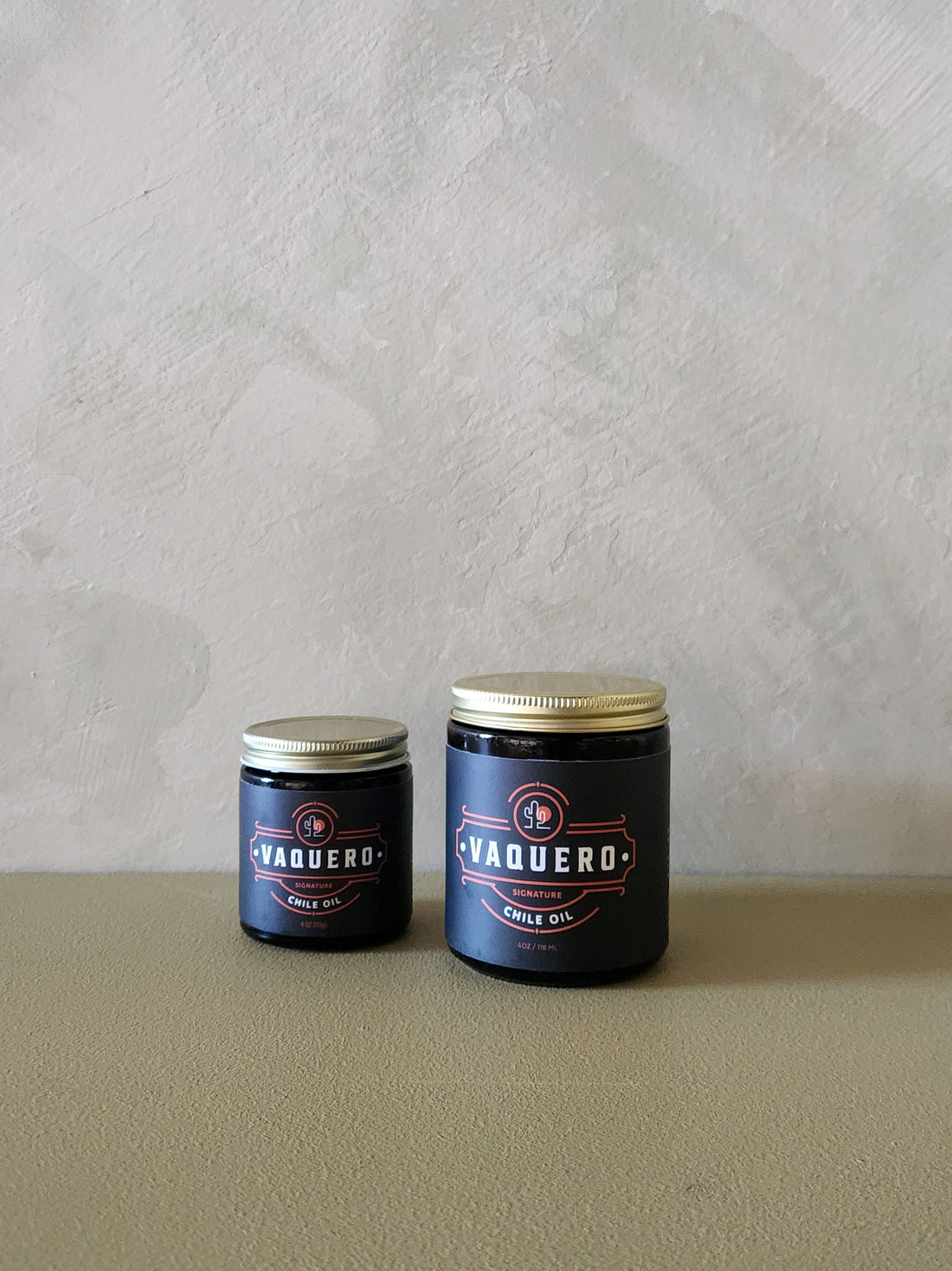 2 jars that say Vaquero on the label on a grey background.