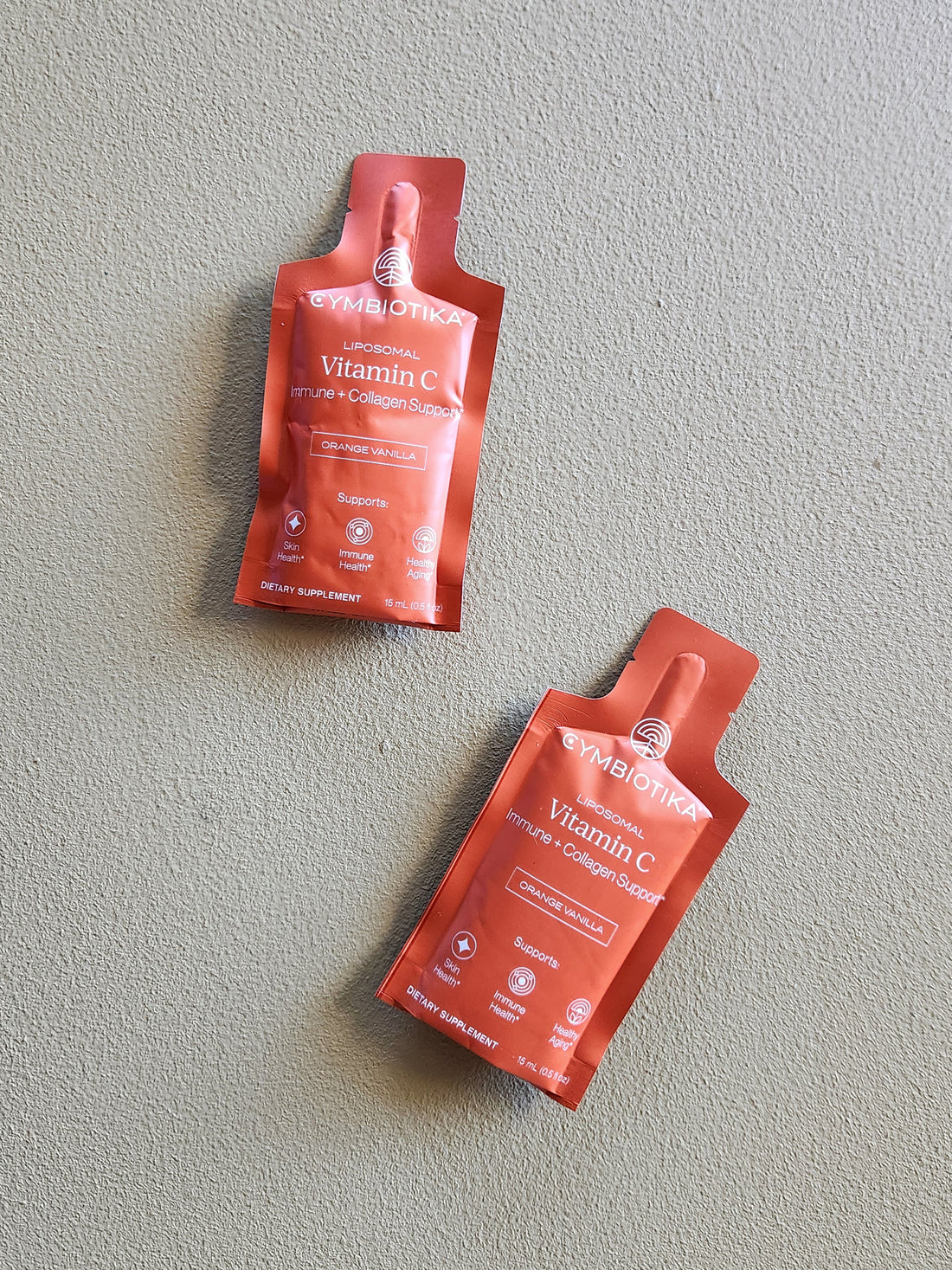 Two red packets of Symprove Vitamin C Collagen Peptide on a gray background
