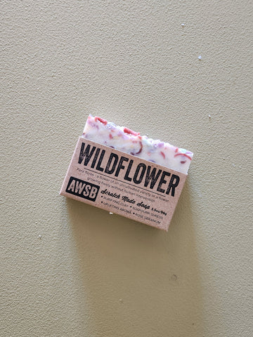 Bar of soap with 'Wildflower' and 'AWSB' branding on a beige background