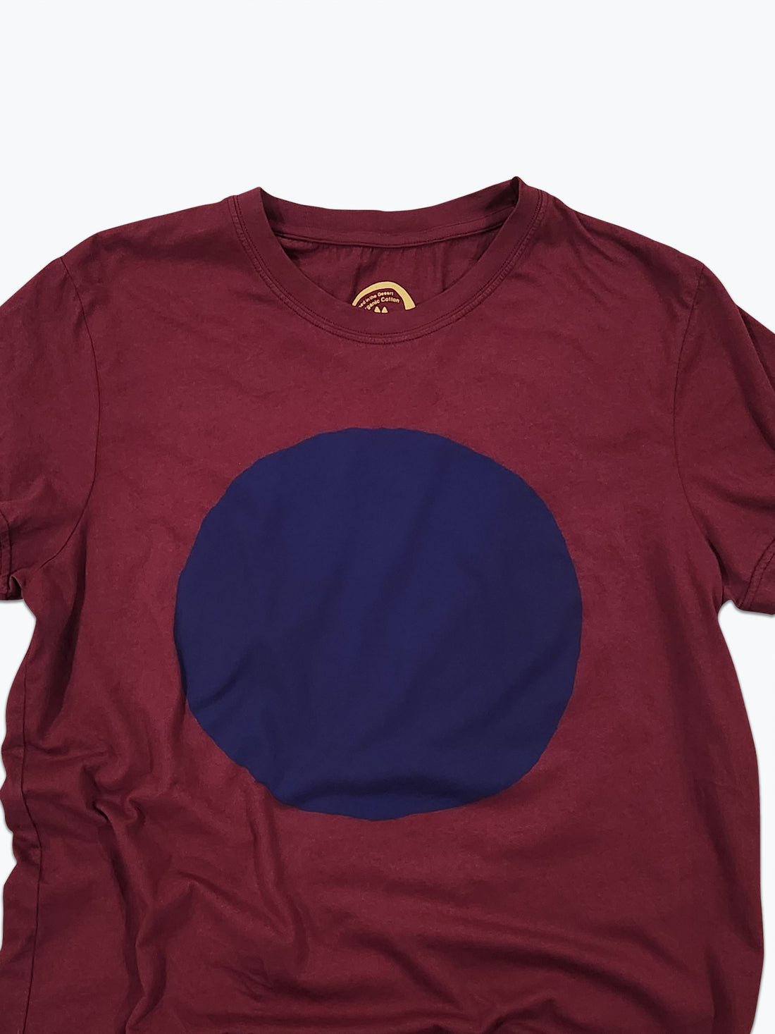 Maroon t-shirt with a large blue circle on a white background