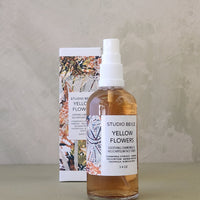 Bottle of 'Yellow Flowers' room spray with a matching box on a neutral background